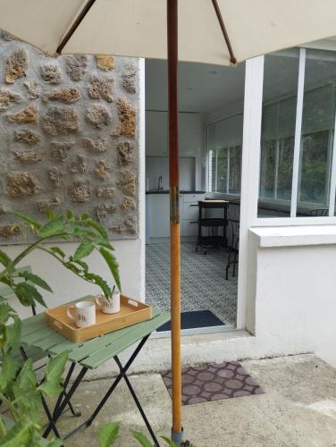 a table with an umbrella on a patio at Studio Athis/Juvisy sur Orge in Athis-Mons