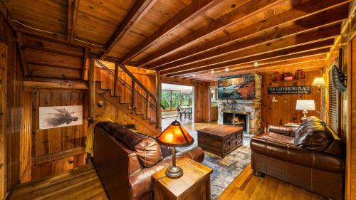 a living room with a leather couch and a fireplace at Whiskey Ridge Lodge, A Restored 1940s Gem, 2 Mins from Downtown, Breathtaking City Views, Custom Game Room, and Spacious Elegance in Gatlinburg