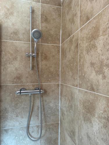 a shower with a shower head in a bathroom at Stunning cozy three bedroom house near ARI in Aberdeen