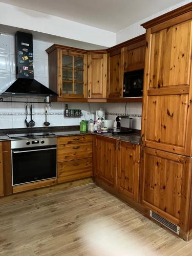 a kitchen with wooden cabinets and a stove top oven at Encanto Natural de Arinaga in Arinaga