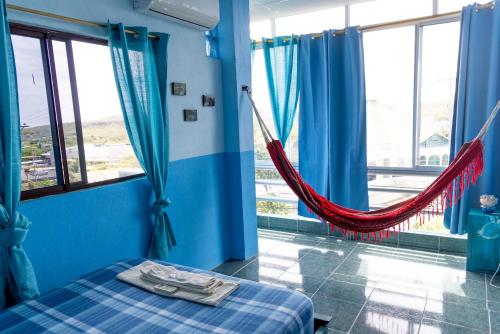 Zimmer mit einem Bett und einer Hängematte. in der Unterkunft Mango Tree in San Cristobal