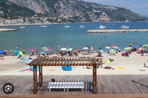 a beach with a bunch of people on it at Studios - Menton Old Town - near the beach and shops in Menton