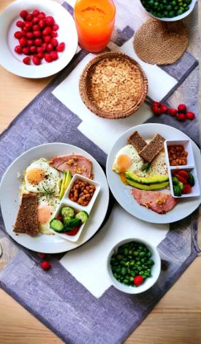 a table topped with plates of breakfast foods and juice at Villa La Fortuna B&B Altos del Maria in Filipina
