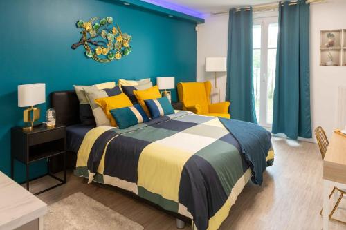 a blue bedroom with a bed and two yellow chairs at LILYA HOUSE in Saint-Pierre-du-Perray