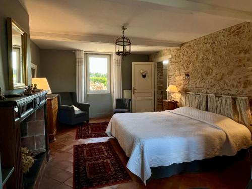 a bedroom with a bed and a stone wall at Le Mas De Marie in Lavaur