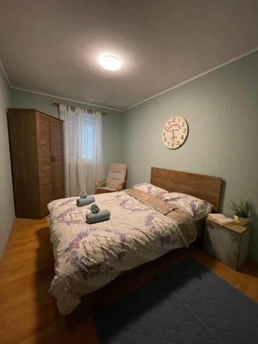 a bedroom with a bed and a clock on the wall at D`or in Kaštel