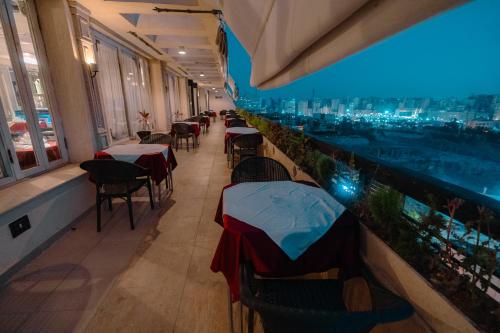 Borg El Thaghr Hotel في الإسكندرية: مطعم بطاولات وكراسي وإطلالة على المدينة