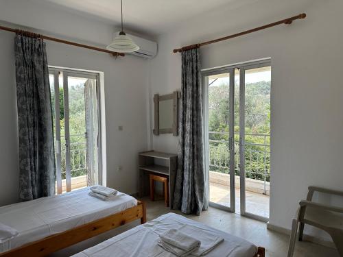 1 dormitorio con 2 camas y ventana grande en FULL HOUSE KAVOS en Kávos