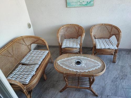 four wicker chairs and a table and a table and chairs at Apartman Batuda,CENTAR, SECURED 2 PARKING SPOT, 5G INTERNET, FREE MINI-ZOO, FREE WELLNESS,SAUNA,BAZEN u obližnjem hotelu nedaleko od apartmana in Ðurđevac