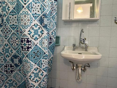 a bathroom with a sink and blue and white tiles at FULL HOUSE KAVOS in Kavos