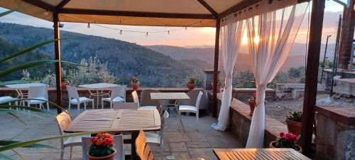 a patio with tables and chairs and a view at Casa del Tramonto in Civitella in Val di Chiana