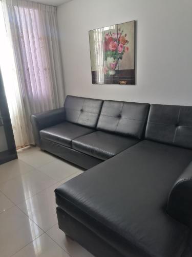 sala de estar con sofá de cuero negro en Residencial Las Torres de Salaverry, en Chiclayo
