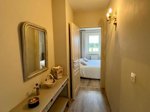 a bathroom with a mirror and a bedroom with a bed at Le Mas De Marie in Lavaur
