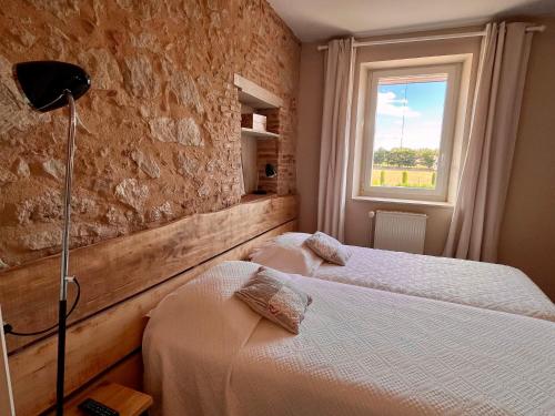a bedroom with two beds and a window at Le Mas De Marie in Lavaur