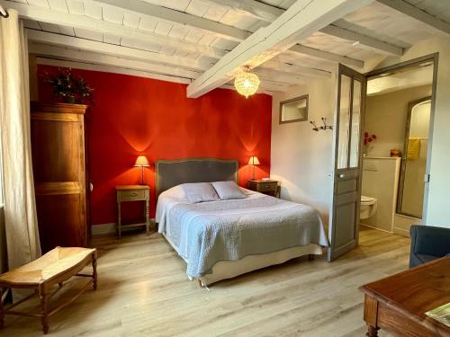 a bedroom with a bed in a red wall at Le Mas De Marie in Lavaur