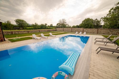 een zwembad met stoelen en een zwembad bij Bekas wine cellar in Akhmety