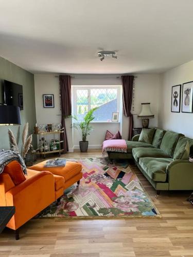 溫莎的住宿－Windsor & Maidenhead 2 bed near Legoland, ascot racecourse and Lapland，客厅配有绿色沙发和地毯。