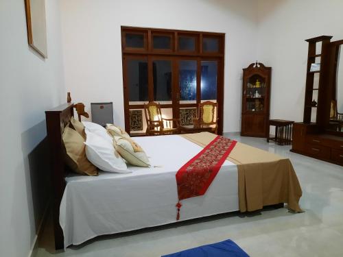 a bedroom with a large bed with white sheets and pillows at "The Anchorage" of Field View in Pannipitiya