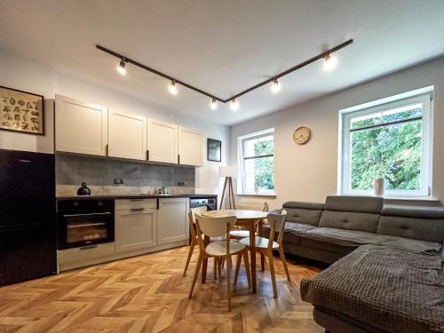 eine Küche und ein Wohnzimmer mit einem Tisch und Stühlen in der Unterkunft Apartament Centrum B in Wejherowo