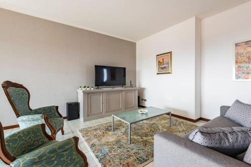 een woonkamer met een bank en een tv bij La casa dell'artista in Verona