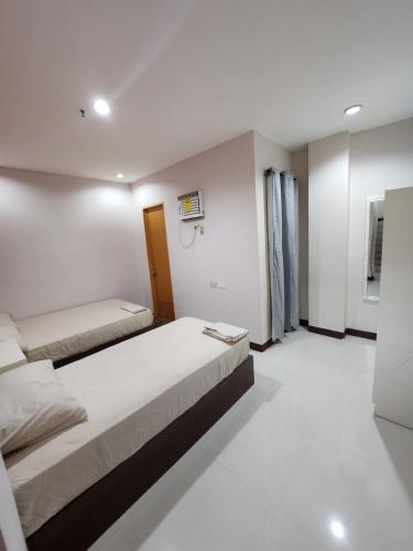 a bedroom with two beds in a room at MANTRA PENSIONNE Standard Room in Cagayan de Oro