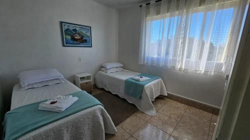 a hospital room with two beds and a window at Residência bem localizada em Bento Gonçalves in Bento Gonçalves