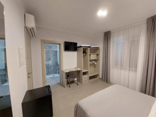 1 dormitorio con cama, escritorio y ventana en Residenza Elba - Charme House en Termoli