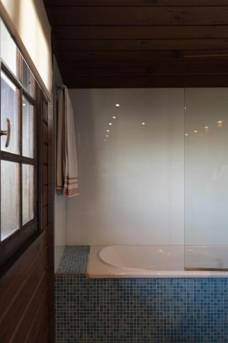 a bath tub in a bathroom with a window at Encantadora moradia T1, com piscina e vista mar a 500m da praia in Viana do Castelo