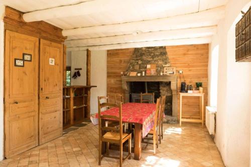 une salle à manger avec une table et une cheminée dans l'établissement L'Ange : Entre monts et vallées, à Retournac