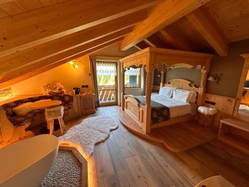 a bedroom with a canopy bed and a balcony at Rifugio Caltena in Fiera di Primiero