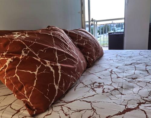 a brown pillow sitting on top of a bed at Studio Apartman K2 in Trebinje