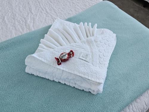 - une serviette blanche avec un anneau sur le lit dans l'établissement Residência bem localizada em Bento Gonçalves, à Bento Gonçalves