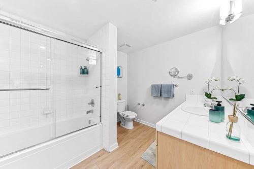 a white bathroom with a shower and a toilet at Emerald Gem 2bedroom 2bath With Full Marina View in Los Angeles