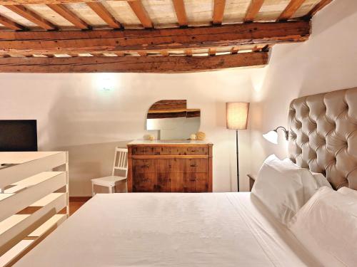 a bedroom with a white bed and a dresser at Hotel Lauri in Macerata