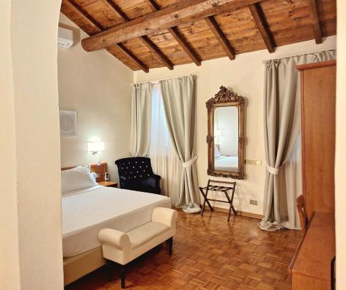 a bedroom with a bed and a mirror and a chair at Hotel Lauri in Macerata
