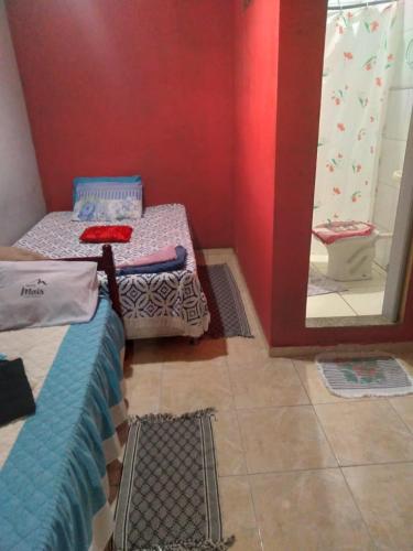 a room with two twin beds and a mirror at Mel Pousada in Macaé