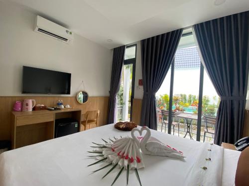 um quarto com uma cama com dois cisnes em Ngoc Trai Xanh Bungalow em Phu Quoc