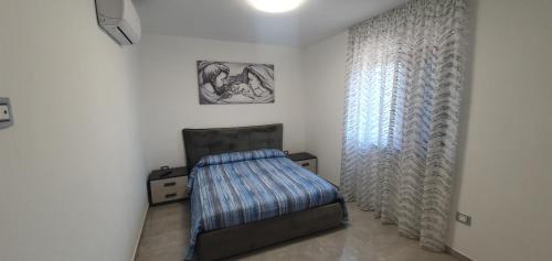 1 dormitorio con cama y ventana en Villa Mary, en Éboli