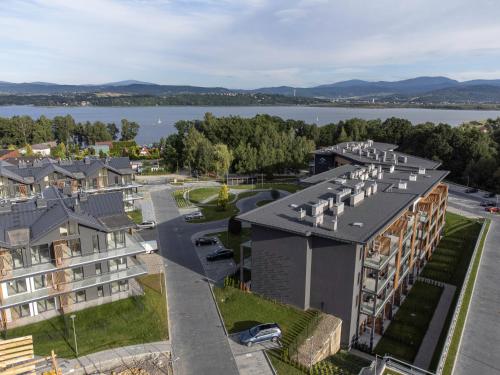 ein Apartmenthaus mit Blick auf das Wasser in der Unterkunft Laguna Resort Beskidy & Wellness in Zarzecze