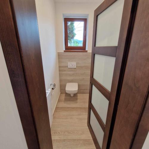 a bathroom with a toilet and a window at Apartment Gemer & Apartment Volovec in Rožňava