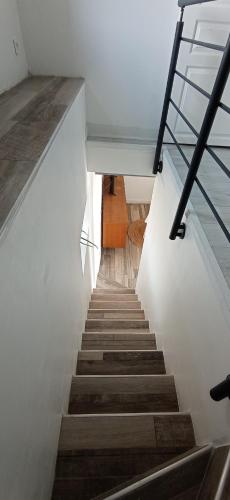 a staircase in a house with white walls and wooden stairs at Le Refuge du Musée in Sacy-le-Grand