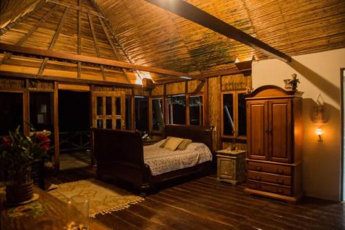 um quarto com uma cama e um tecto de madeira em Puntita Manzanillo, fantastic sea and jungle retreat em La Guayra