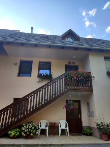 a house with a balcony with a table and chairs at Počitniško stanovanje Aurora in Bovec