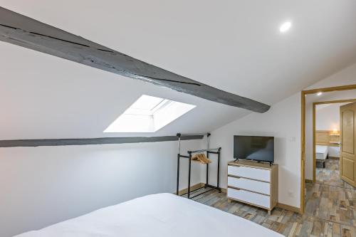 een slaapkamer op zolder met een bed en een televisie bij Centre Historique - FREE Parking - Self Checkin - WIFI - LA CABANE - SLEEPNTRIPBEZIERS in Béziers