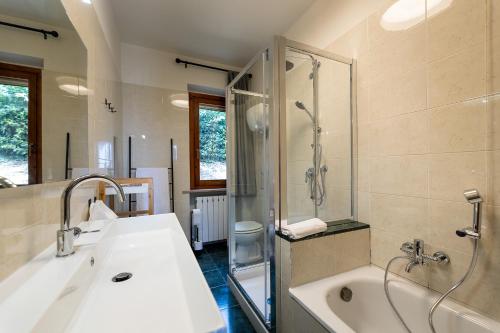 a bathroom with a tub and a sink and a shower at Villa Degli Olivi is located in Saragano in Saragano