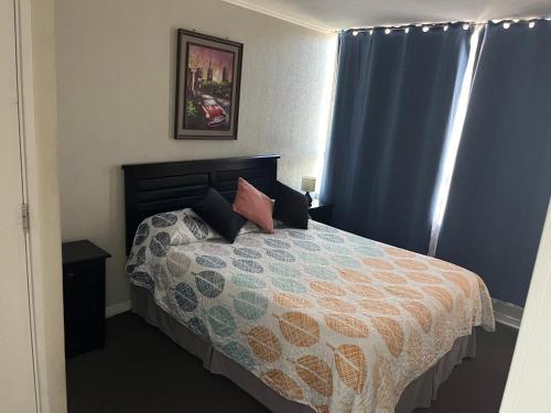 a bedroom with a bed and blue curtains at Cómodo departamento Cerca de Metro in Santiago