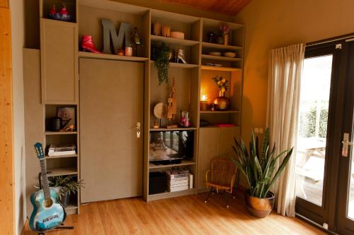 a living room with a book shelf with a tv at Tukken op de Maashorst in Schayk