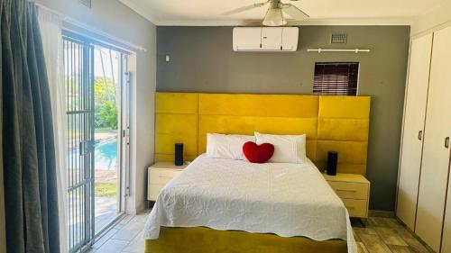 een slaapkamer met een bed met een rood hart erop bij Kuhle's Guest House in Richards Bay