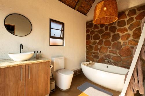 ein Badezimmer mit einer Badewanne, einem WC und einem Waschbecken in der Unterkunft Elephants Crossing in Welgevonden Game Reserve