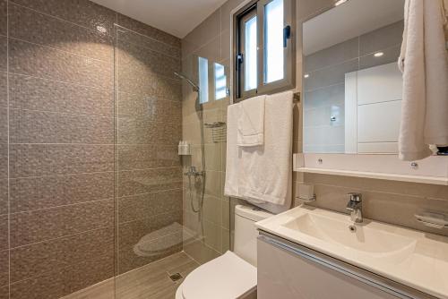 a bathroom with a toilet and a sink and a shower at Hotel Stay Here Suites in Santo Domingo